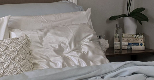 white bed with crumpled pillows with bedstand