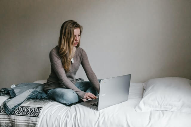 lady working on laptop on a single bed