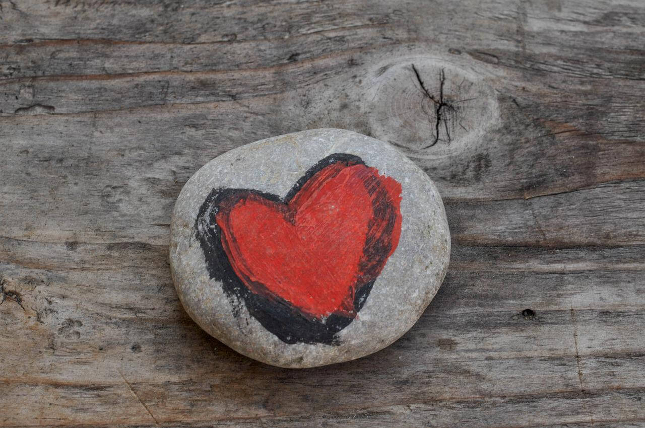 donate painted heart on stone on wood